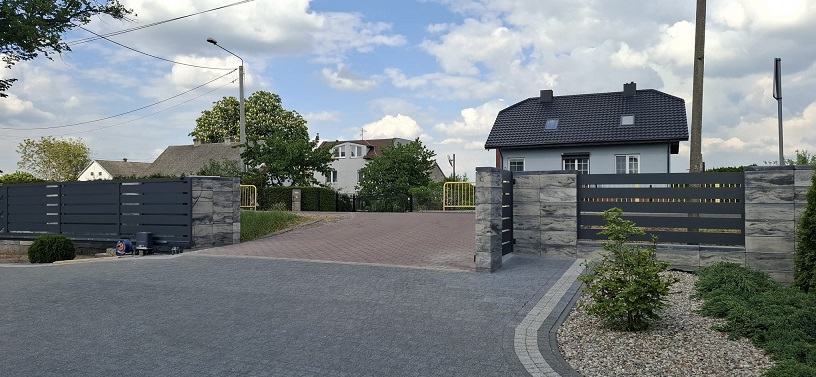 Zamontowane ogrodzenie z bramą uchylną przy domu jednorodzinnym